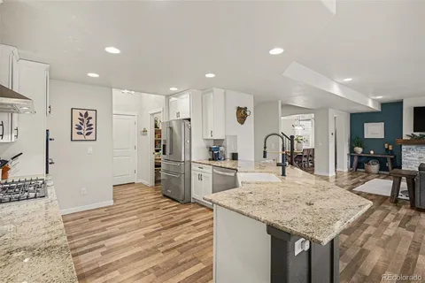 a kitchen with stainless steel appliances kitchen island granite countertop a refrigerator and a sink
