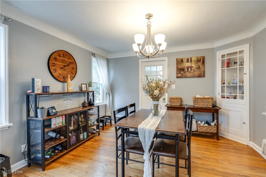 1375 Gordon Road Lyndhurst, OH 44124 - Photo 10 of 34 Dining room with a chandelier, light wood-style flooring, and ornamental molding