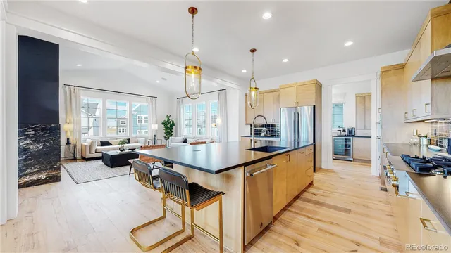 a large kitchen with kitchen island a large counter top appliances and a view of living room