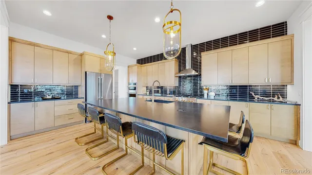 a kitchen with stainless steel appliances granite countertop a sink a stove and a refrigerator