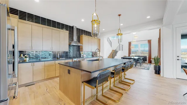 a kitchen with stainless steel appliances granite countertop a sink a stove and a wooden floors