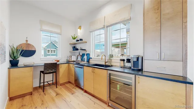 a kitchen with stainless steel appliances kitchen island granite countertop a stove a sink and white cabinets with wooden floor