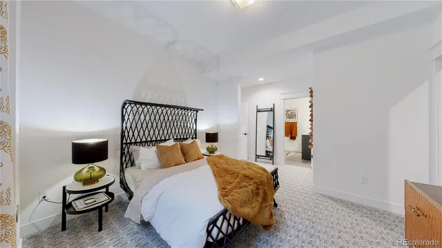 a bed room with a bed and painting on the wall