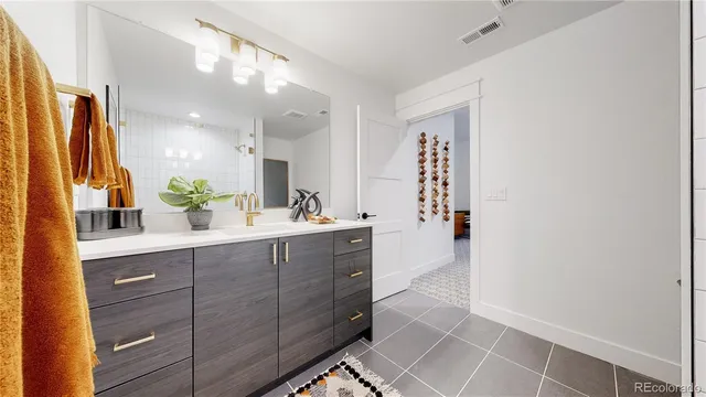 a spacious bathroom with a double vanity sink a mirror and a shower