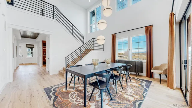 a dining room with wooden floor a chandelier a wooden table and chairs