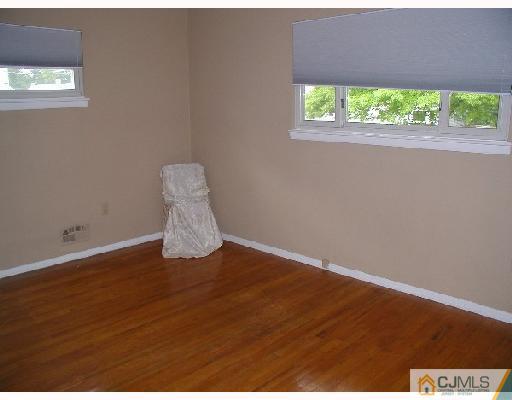 188 North Hill Road Colonia, NJ 07067 - Photo 6 of 10 an empty room with wooden floor and a table