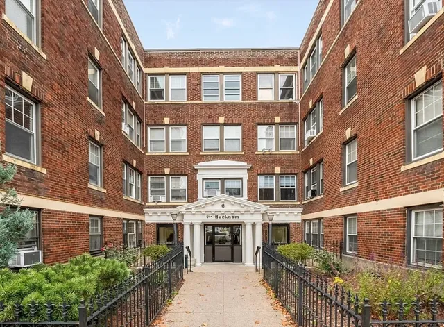 a front view of a building with a garden