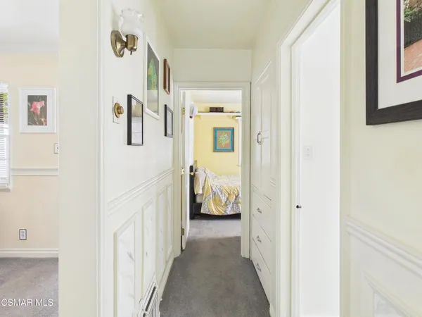 a view of a hallway with bedroom and wooden floor