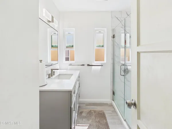 a bathroom with a sink a mirror and a shower