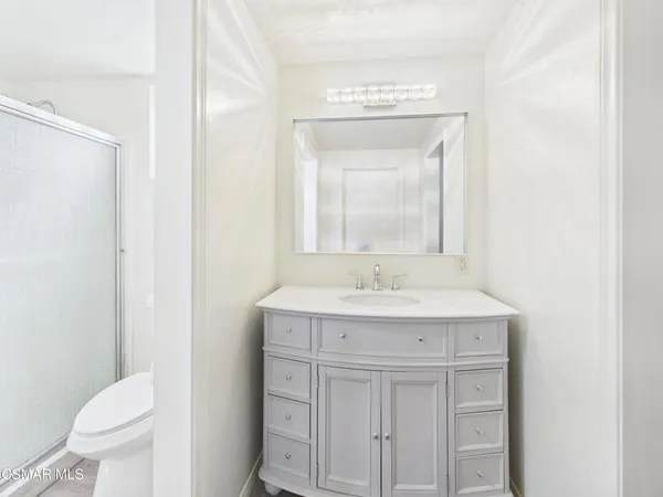 a bathroom with a toilet a sink a vanity and mirror