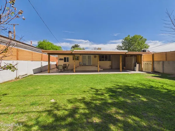 a view of a house with a backyard and a patio