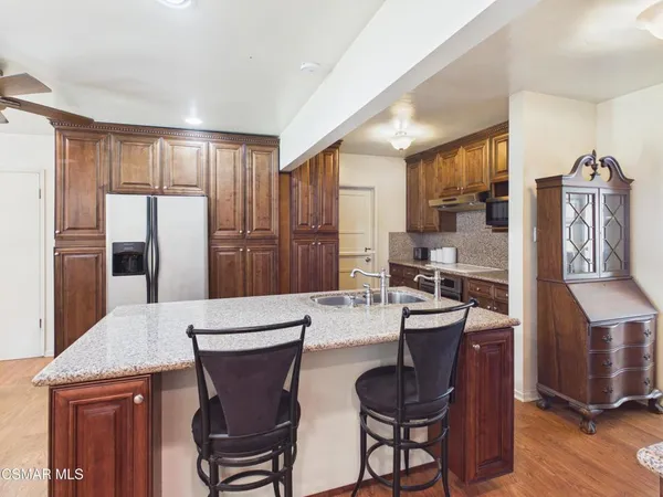 a kitchen with stainless steel appliances wooden floor dining table and chairs
