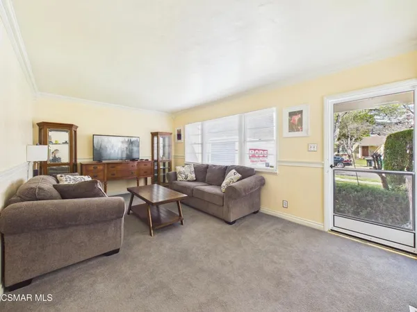 a living room with furniture and a floor to ceiling window