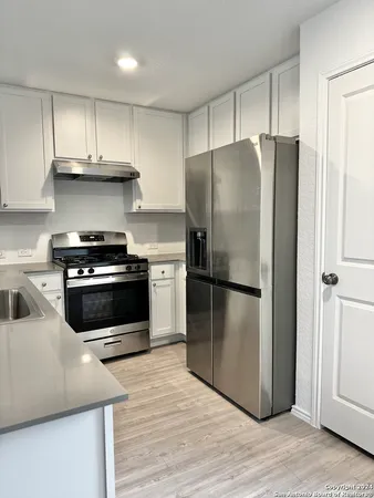 a kitchen with a refrigerator and a stove top oven