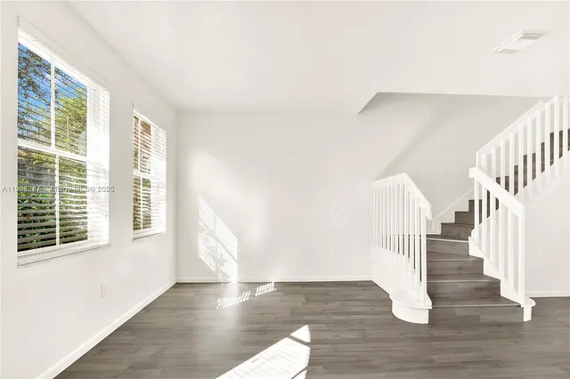 a view of entryway and hall with wooden floor