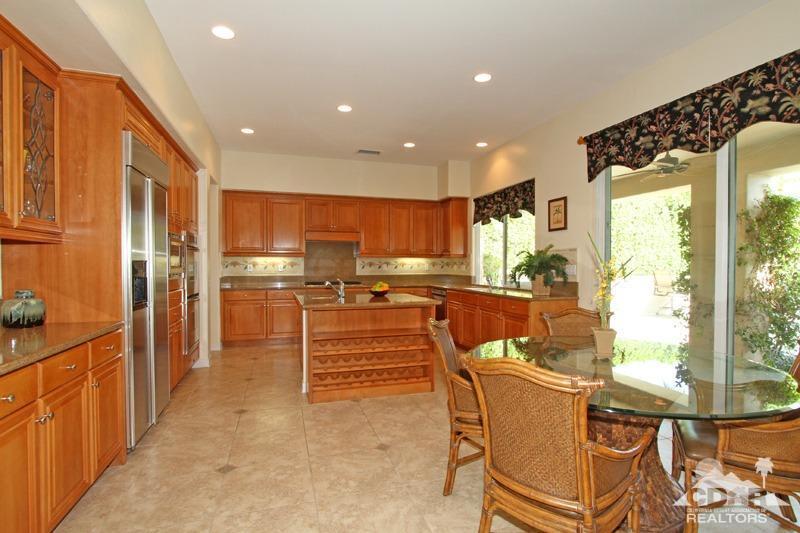 346 Loch Lomond Road Rancho Mirage, CA 92270 - Photo 11 of 34 a kitchen with stainless steel appliances kitchen island granite countertop a refrigerator and cabinets