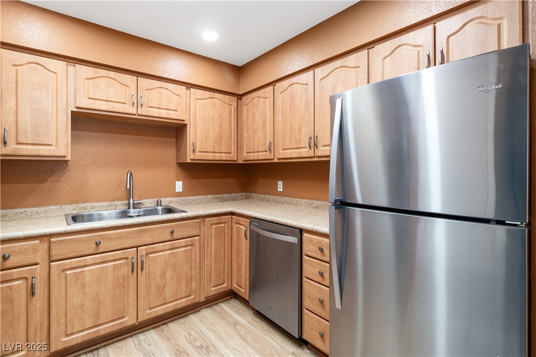 1948 Las Palmas Lane, Unit 277 Laughlin, NV 89029 - Photo 17 of 71 Kitchen with stainless steel appliances, light brown cabinets, light wood-type flooring, light countertops, and a textured wall