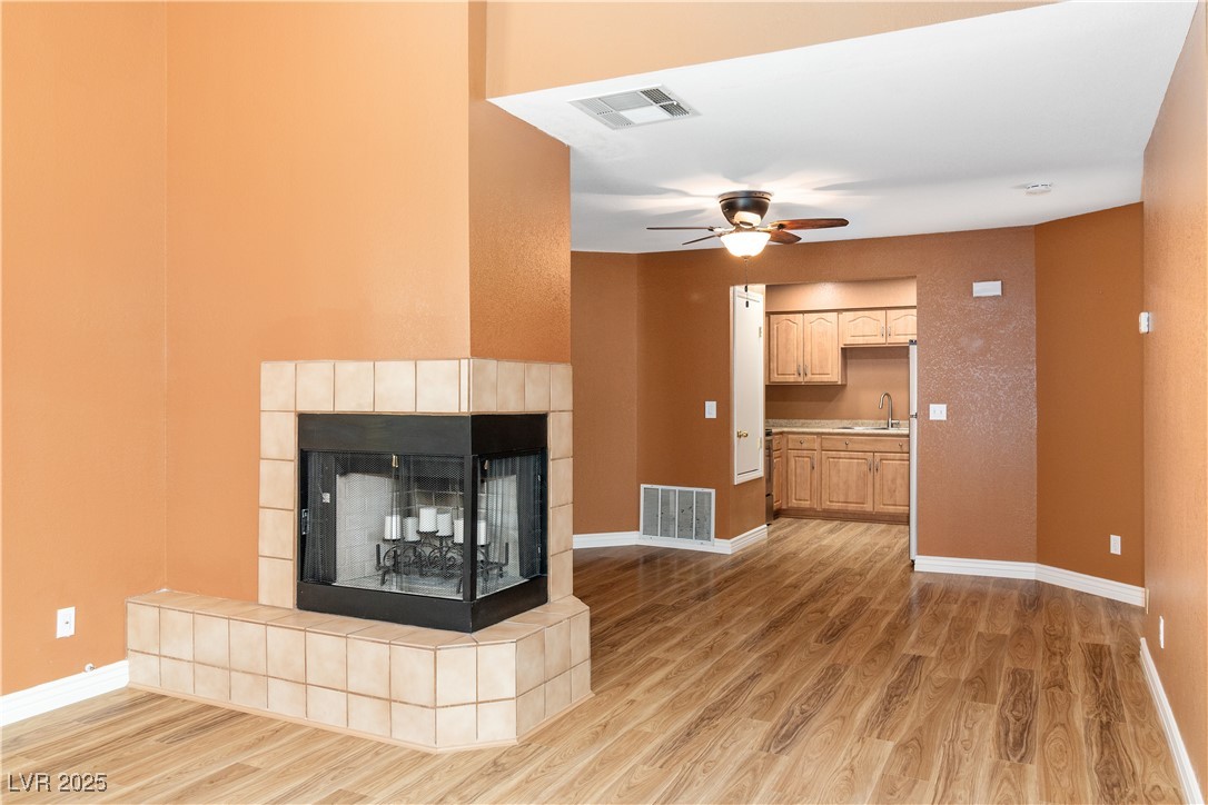 1948 Las Palmas Lane, Unit 277 Laughlin, NV 89029 - Photo 8 of 71 Unfurnished living room with light wood-type flooring, ceiling fan, and a fireplace
