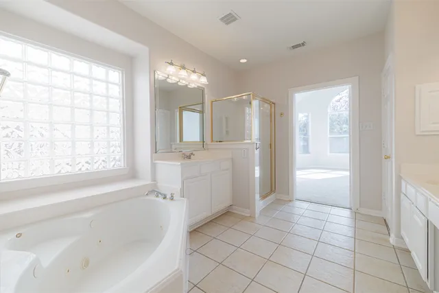 a bathroom with a bathtub a shower and a sink