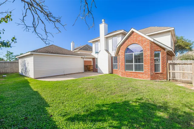 a view of a yard in front of a house with large tree