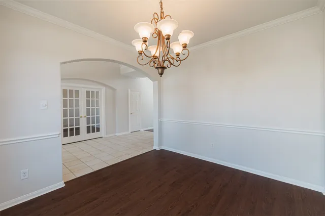 a view of a chandelier in big room with wooden floor