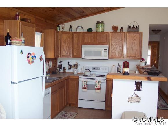 460 Barn Cove Road Clyde, NC 28721 - Photo 11 of 24 a kitchen with stainless steel appliances granite countertop a refrigerator a sink a stove and a refrigerator