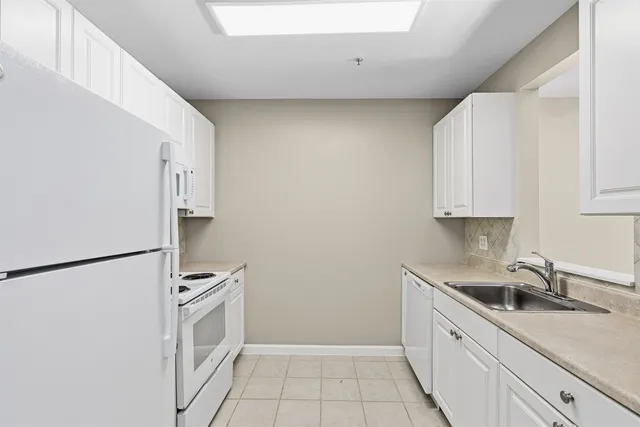 a kitchen with a sink a refrigerator and cabinets