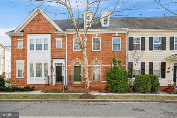 front view of a brick house with a small yard