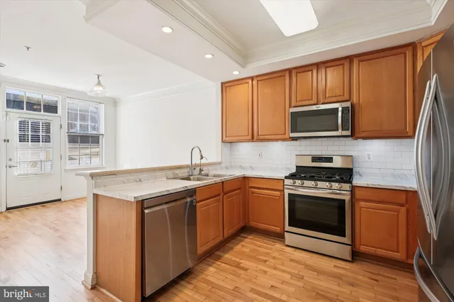 a view of a kitchen with wooden floor and electronic appliances