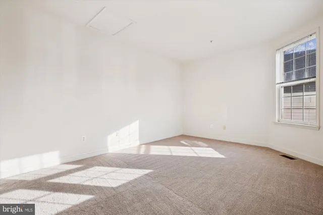 an empty room with windows and ceiling fan