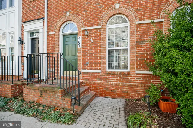 a view of an empty room with wooden floor and a fireplace
