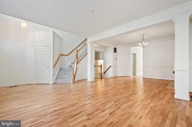 a view of an empty room with wooden floor fireplace and a window