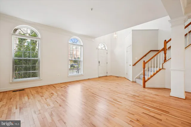 a view of empty room with wooden floor and stairs