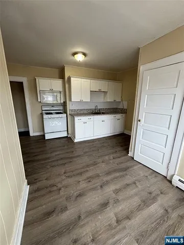 a kitchen with stainless steel appliances wooden cabinets and wooden floor