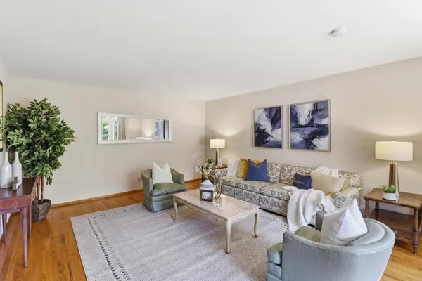 a view of a dining room with furniture a chandelier and wooden floor