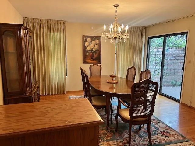 a dining room with furniture a chandelier and wooden floor