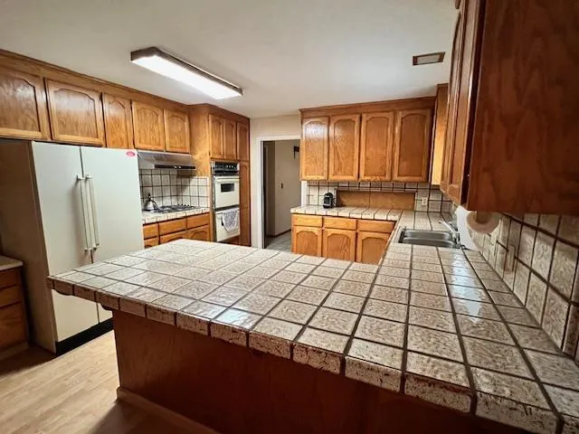 a kitchen with stainless steel appliances granite countertop a refrigerator sink and cabinets