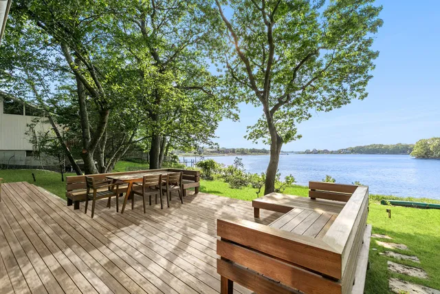a view of a patio with table and chairs potted plants and large tree
