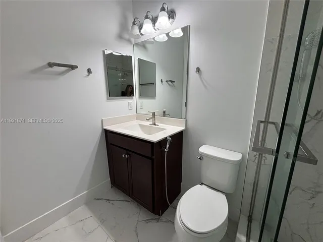 a bathroom with a sink vanity mirror and toilet