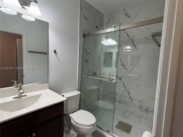 a bathroom with a sink shower and a mirror