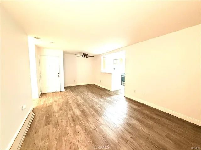 a view of empty room with wooden floor