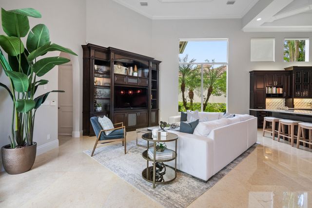 a living room with patio furniture and a potted plant