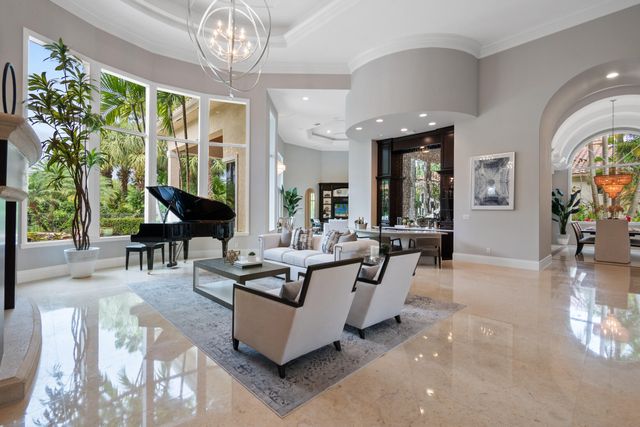 a living room with fireplace furniture and a large window