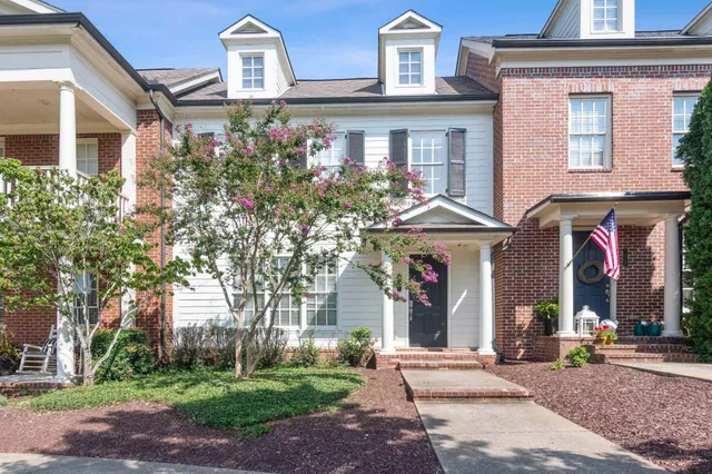 front view of a brick house with a yard