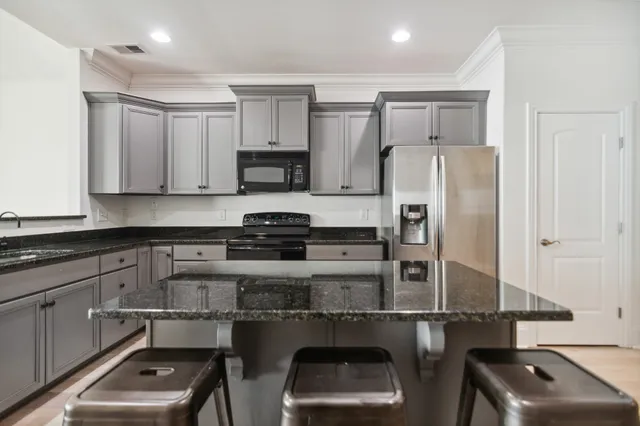 a view of a kitchen with a dining table chairs and white cabinets