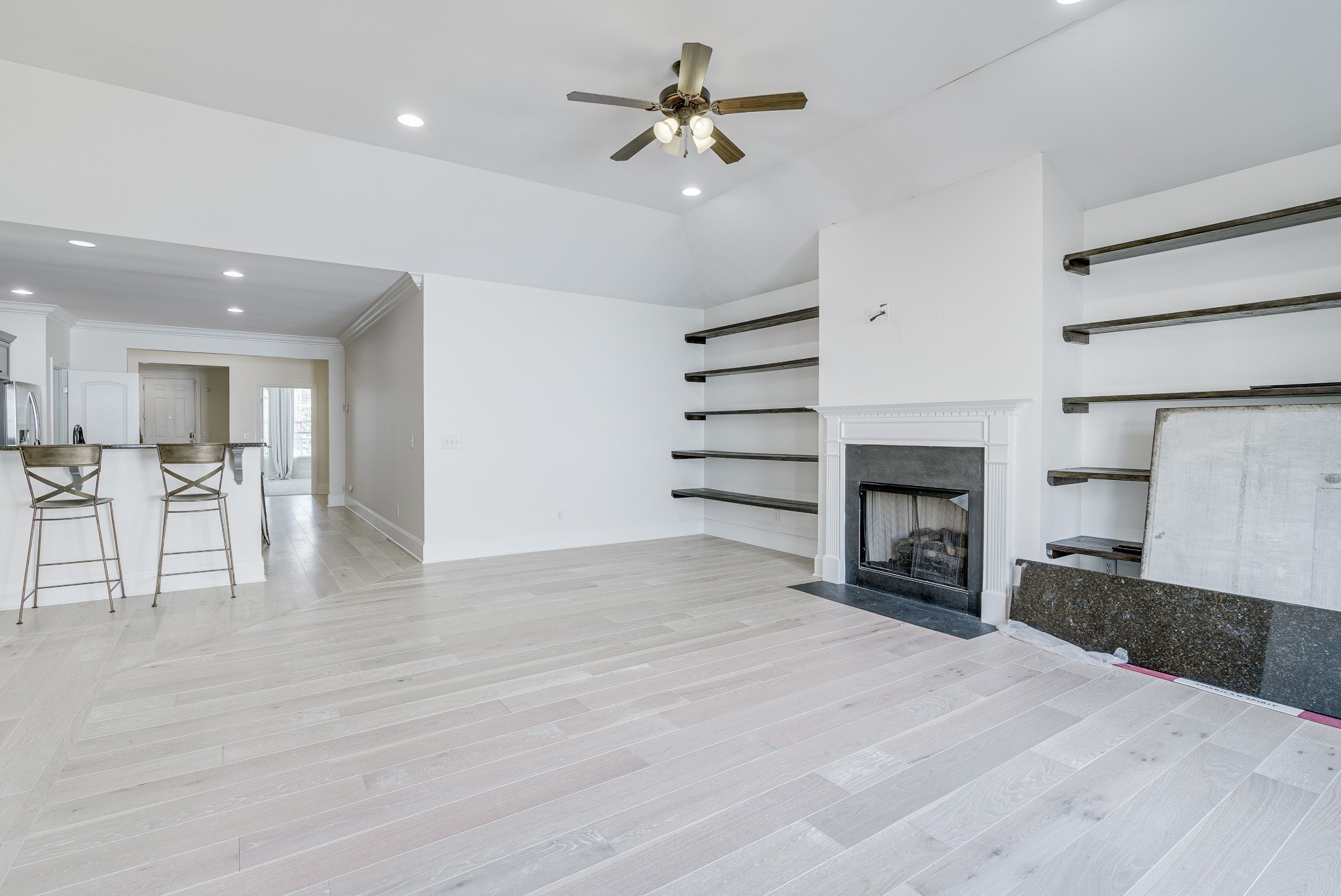 1024 Rochelle Avenue Thompson's Station, TN 37179 - Photo 15 of 37 a view of a livingroom with a fireplace a ceiling fan and a kitchen counter top space