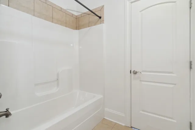 a white bath tub sitting next to a shower