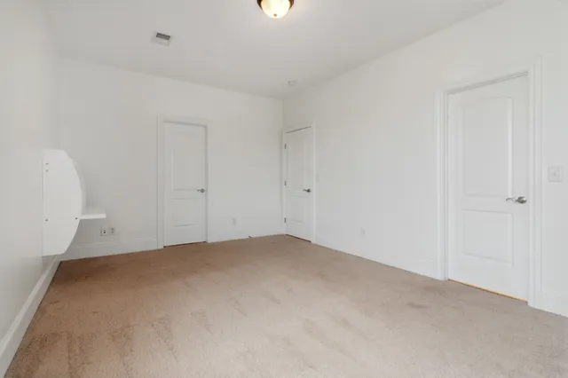 an empty room with windows and closet