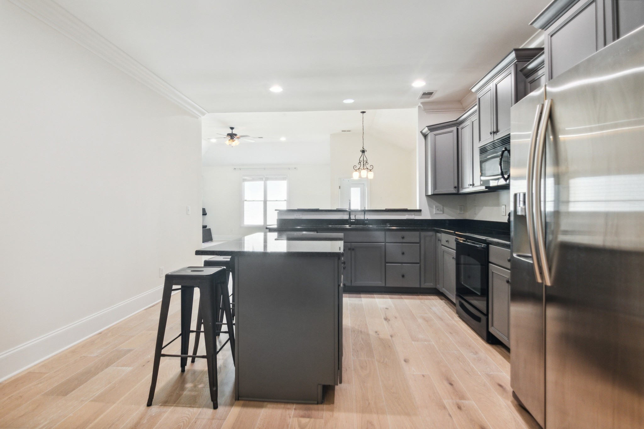 1024 Rochelle Avenue Thompson's Station, TN 37179 - Photo 7 of 37 a kitchen with stainless steel appliances kitchen island granite countertop a stove a sink and a refrigerator