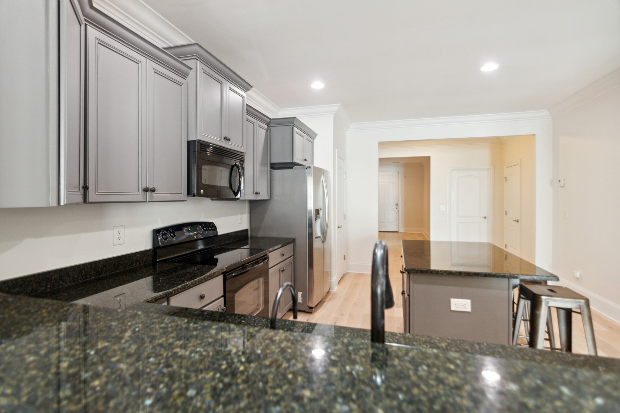 1024 Rochelle Avenue Thompson's Station, TN 37179 - Photo 8 of 37 a kitchen with stainless steel appliances a sink a stove a microwave a refrigerator and cabinets
